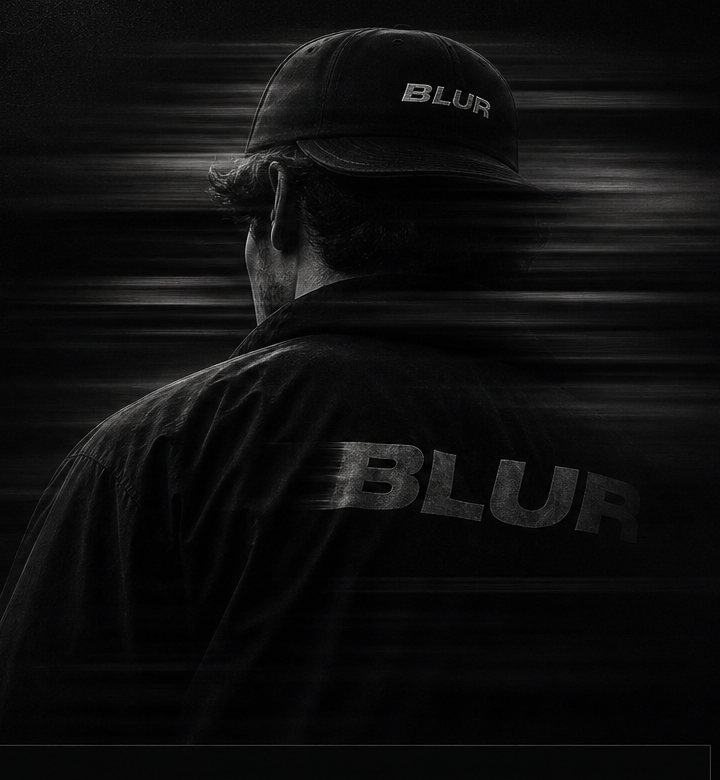 A person in a BLUR cap and jacket turned into motion blur.